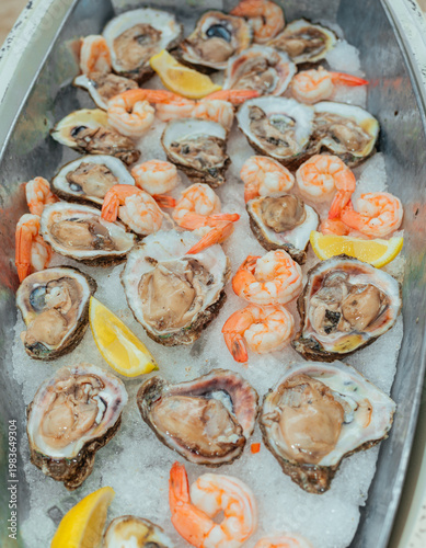 Fresh oysters and shrimp served on ice with lemon wedges