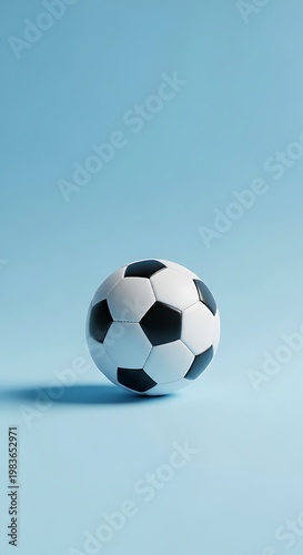 A classic black and white soccer ball rests on a smooth, pale blue surface