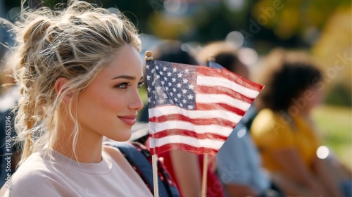 Young Woman Holds American Flag at Outdoor Event During Daytime in a Public P...