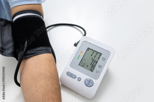 Close up of digital blood pressure monitor with cuff on patient arm