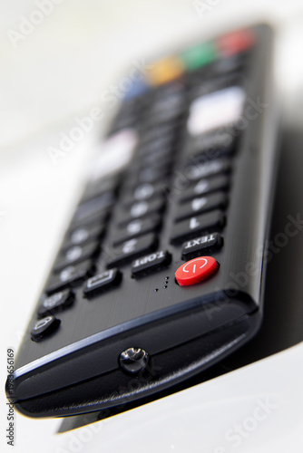 Close up of remote control with red power button and shallow focus