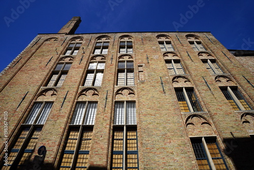 Kunstvoll restaurierte alte Kaufmannshäuser aus Backstein mit Klinkerfassade und Rundbogen als Unesco Weltkulturerbe in den Gassen der Altstadt von Brügge in Westflandern in Belgien	
