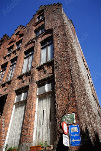 Verkehrszeichen und schöne alte Backsteinfassade mit Treppengiebel bei blauem Himmel und Sonnenschein in den Gassen der Altstadt von Brügge in Westflandern in Belgien