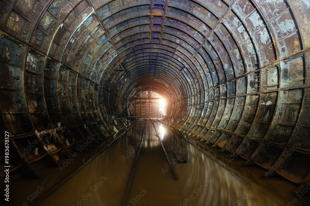 Fototapeta premium Flooded dark abandoned rusty underground subway construction tunnel