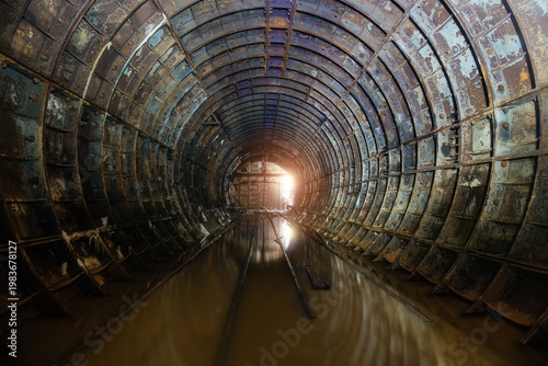Flooded dark abandoned rusty underground subway construction tunnel