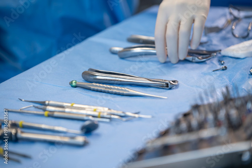 Instruments dentaires stériles sur table de soin avec main de praticien en gants