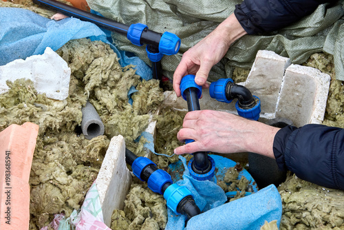 Well contractor repairing well pit water distribution piping.