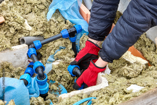 Repair of HDPE distribution piping in artesian well pit homeowner using compression fittings to connect pipe sections.