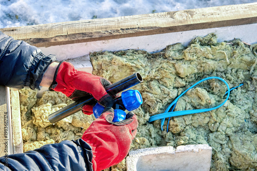 Plastic compression tee fitting in hands of well contractor.