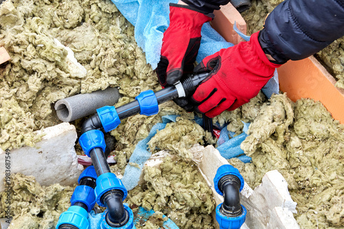 Plumber moving compression ring of compression fitting for HDPE pipes along pipe.