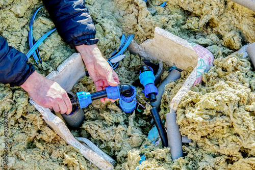 Distribution piping in artesian well pit well contractor using compression fittings to connect pipe sections.