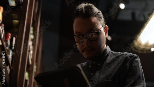 Wallpaper Mural Night club concept of 4k Resolution. Asian man checking the stock of liquor on the shelf. Torontodigital.ca