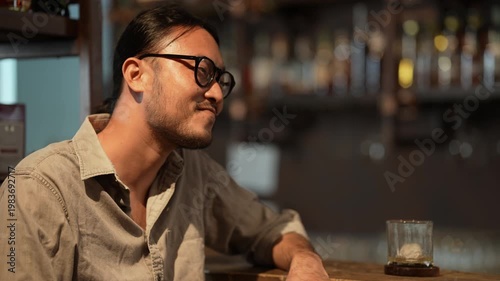 Wallpaper Mural Night club concept of 4k Resolution. A young Asian man is drinking alcohol at the counter of a pub. Torontodigital.ca