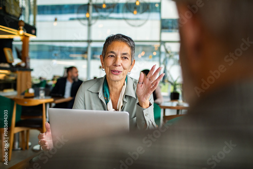 Senior businesswoman consulting a client in modern cafe