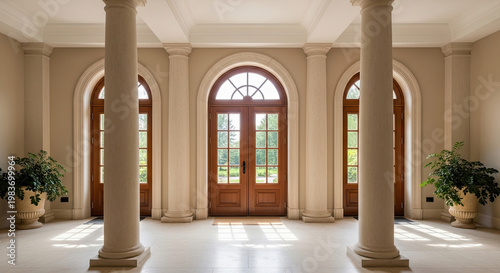 Elegant arched doorway entrance with symmetrical columns and sunlight in luxury home foyer classic architectural design in beige tones