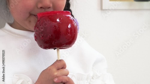 りんご飴を食べている女の子のイメージ（5歳、日本人）