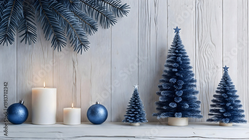 Festive scene with blue artificial Christmas trees and ornaments arranged on a white wooden shelf, accompanied by lit pillar candles, evoking a serene holiday ambiance.