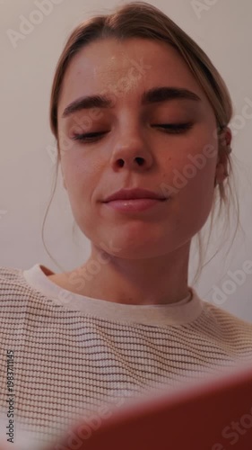 Young Woman Relaxing at Home While Reading a Book