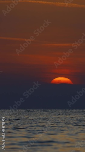 the sun is sinking into the sea. possible to accelerate the image stream. vertical video for social media.	
