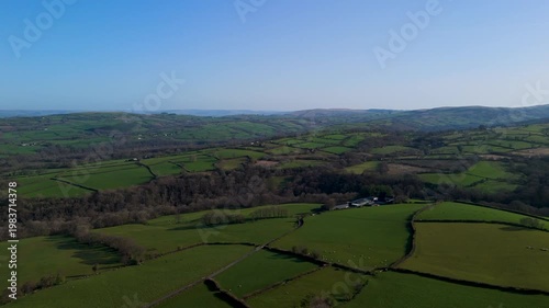 Aerial view of green patchwork farmland and rolling hills