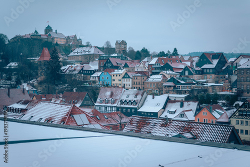 Blick über verschneite Dächer der Altstadt von Kronach auf die Festung Rosenberg im Winter