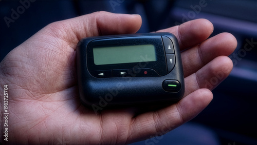 Close up shot of hand holding a 1990s-era pager. AI-generated