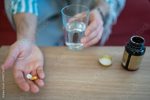 Person taking daily medication and health supplements