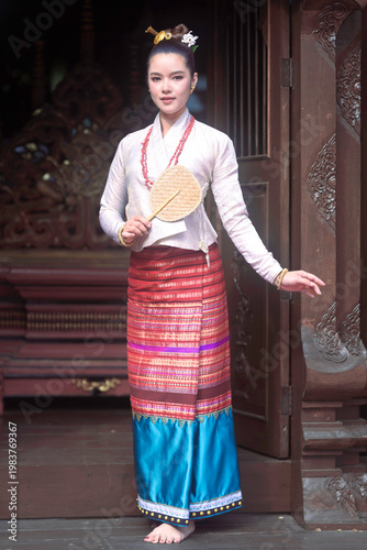 Beautiful Asian woman in traditional Tai Lue dress at Lanna house.