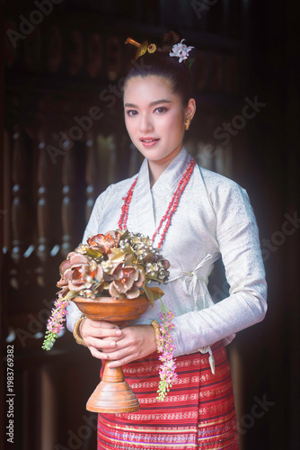 Beautiful Asian woman in traditional Tai Lue dress at Lanna house.