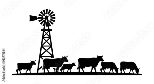 Silhouette of a herd of cattle grazing near a windmill on a farm.