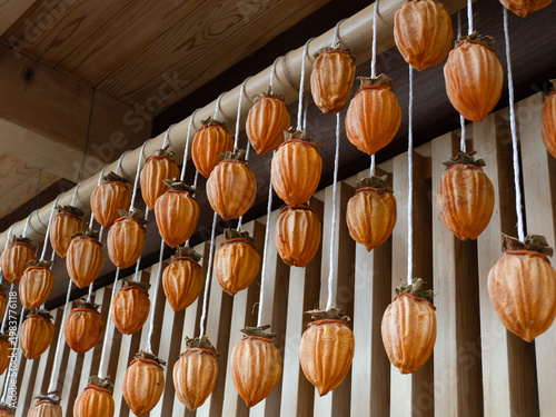 住宅の軒先に吊るした干し柿