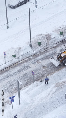 Snow removal in residential area, tractor clearing road after snowfall, winter urban maintenance