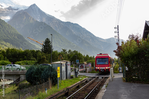 Chamonix-Mont-Blanc, Haute Savoie, France - August 09th, 2025: Level crossing of an SNCF train in Les Pelerins, with the train's electrical power supplied by direct current via a dangerous third rail.