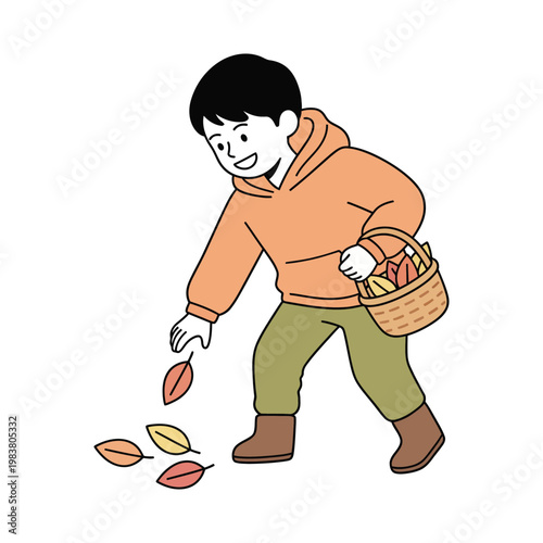 A happy boy wearing an orange hoodie and green pants, bending down to collect fallen autumn leaves into a wicker basket