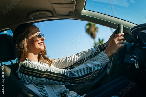 Businesswoman driving modern car on sunny day