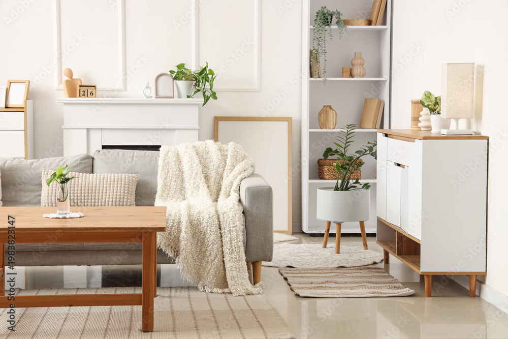 Obraz premium Interior of light living room with sofa, table and plants