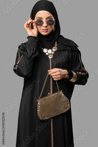 Photos Beautiful young stylish Muslim woman in black hijab with golden accessories and