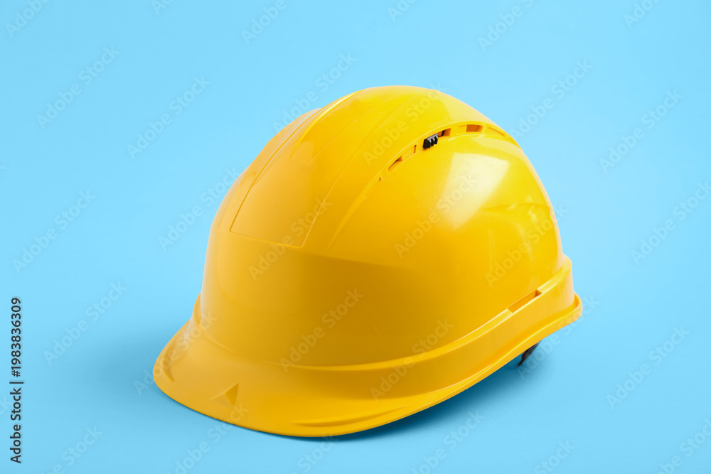Fototapeta premium Yellow hardhat on blue background
