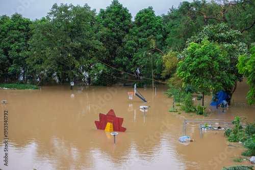 Flooded park area in Hanoi with submerged playground equipment and trees, illustrating rising Red River levels after prolonged storm conditions.