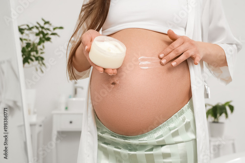 Young pregnant woman applyi...