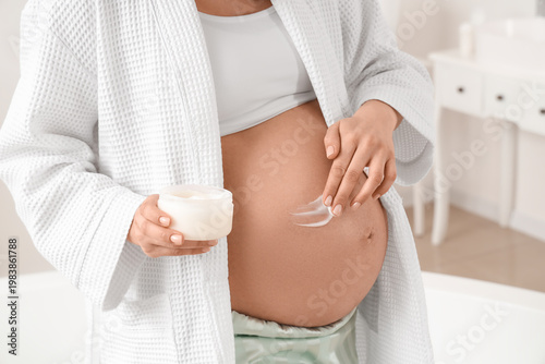 Young pregnant woman applyi...