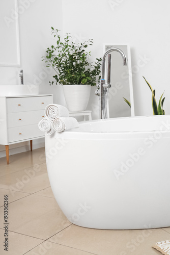 Clean towels on bathtub in ...