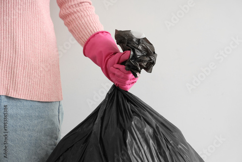 Woman with garbage bag near...