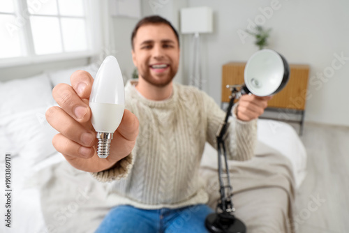 Young man changing light bu...