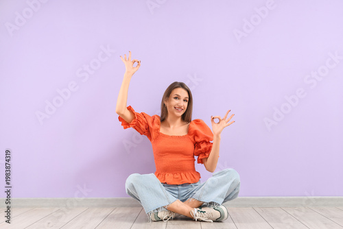 Young woman showing OK near...