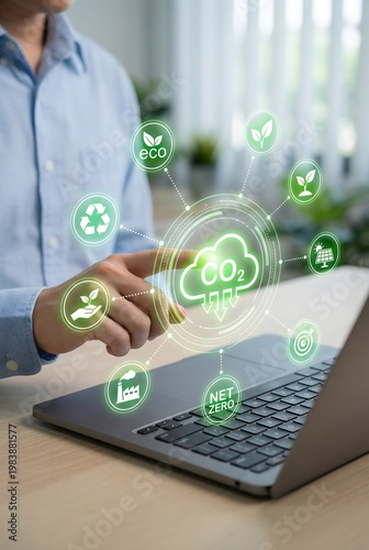 Man pointing at a laptop screen displaying co2 reduction icons and sustainability graphics.