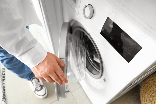 Young man opening washing m...