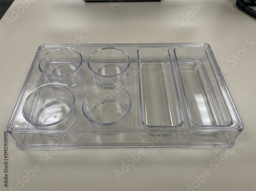 Clear plastic food container with divided sections and a round compartment