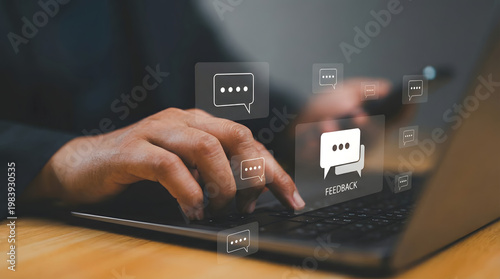 A person types on a laptop keyboard with floating digital feedback speech bubble icons