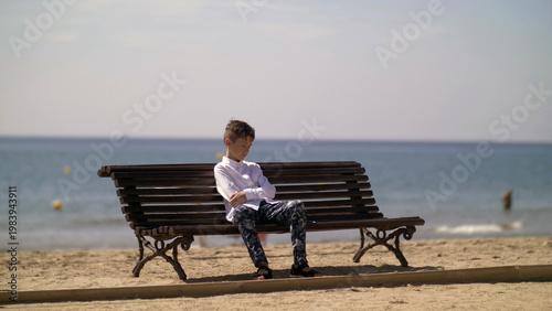 funny boy is tired and sleep on a bench near the beach, have fun and enjoy